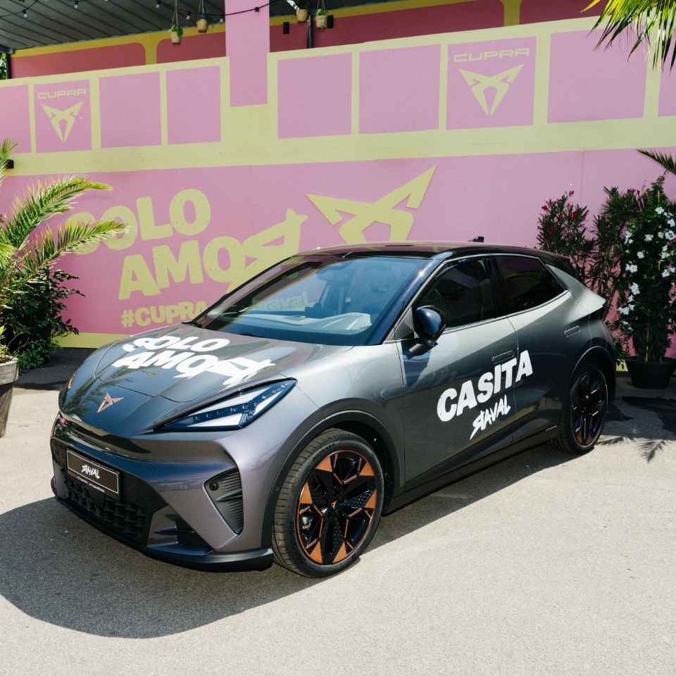 Der neue CUPRA Raval mit „SOLO AMOR"-Schriftzug auf der Haube, geparkt auf dem Stadtstrand der Casita Raval.
