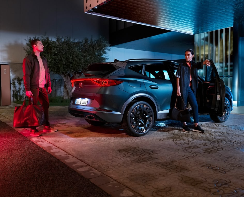Der CUPRA Formentor steht als sportlicher Crossover‑SUV in moderner urbaner Umgebung bei Nacht. Markante Linien, dynamische Leichtmetallfelgen und die beleuchtete Heckpartie betonen das progressive Design von CUPRA. 