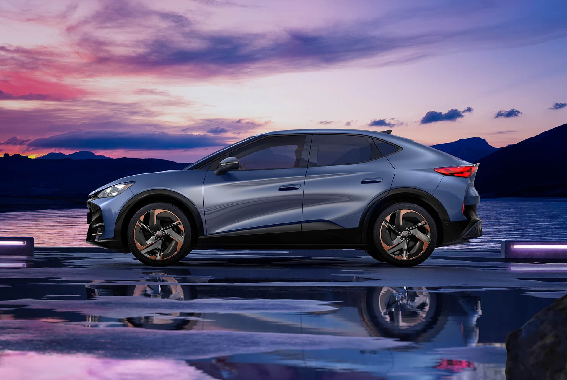 CUPRA Tavascan Elektroauto-Angebot, SUV-Coupé in Tavascan-Blau mit 21-Zoll-Katla-Felgen. Glasplatte und Himmelhintergrund.