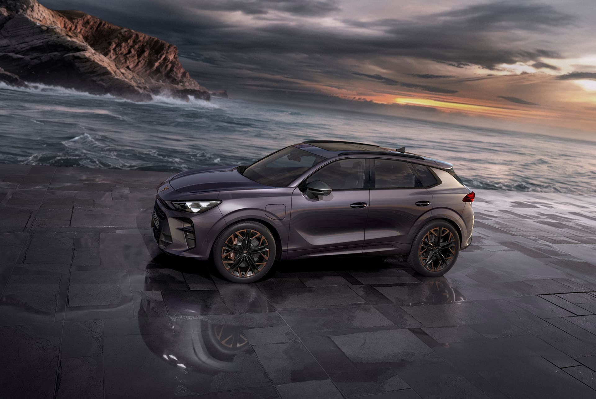 Cupra Terramar SUV in Timanfaya-Grau, Modelljahr 2025, mit 19-Zoll-Felgen in Cosmic Copper bei Sonnenuntergang am Meer. Hybrid-SUV zu verkaufen.