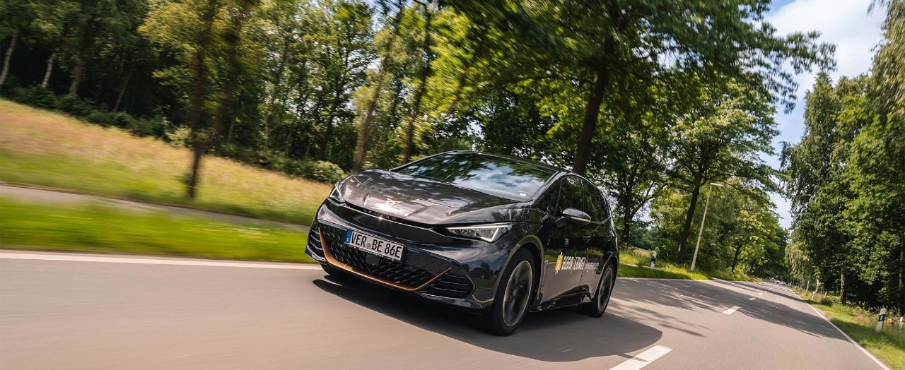 CUPRA Born fahrend auf einer Landstraße. 