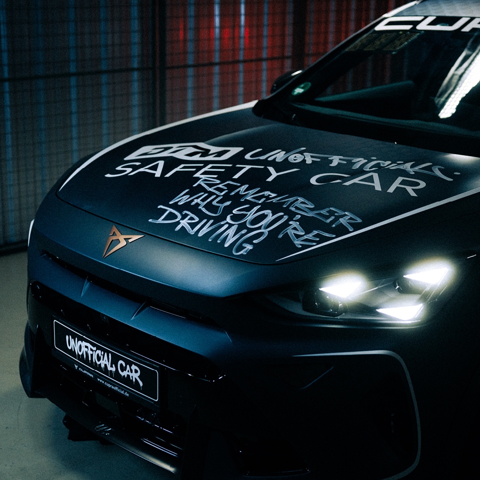 Heckansicht eines CUPRA Formentor bei Nacht mit leuchtenden Rückleuchten und Graffiti-Schriftzug »Unofficial – Folge deinem Instinkt«
