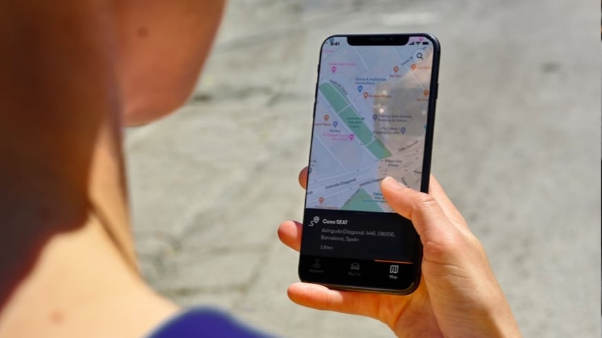 Smartphone zeigt CUPRA CONNECT App mit Online-Infotainment-Funktionen wie Navigation, Medien und Fahrzeugstatus.