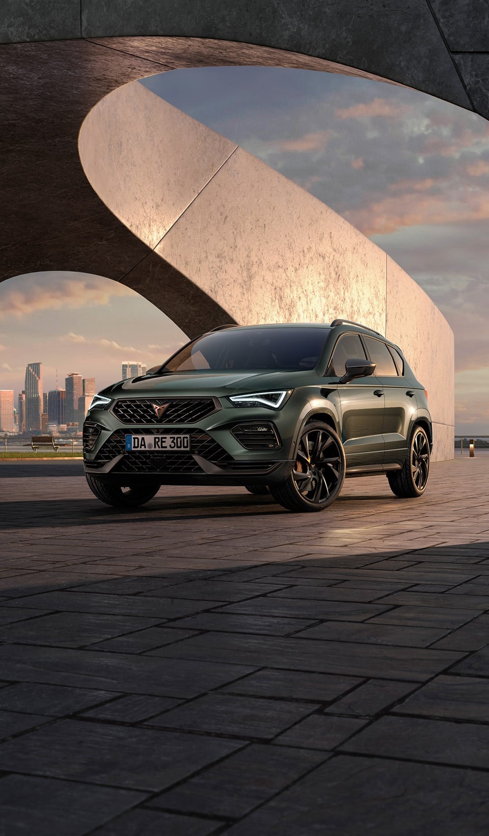 Ein CUPRA Ateca geparkt vor Stadtkulisse, Frontalaufnahme. 