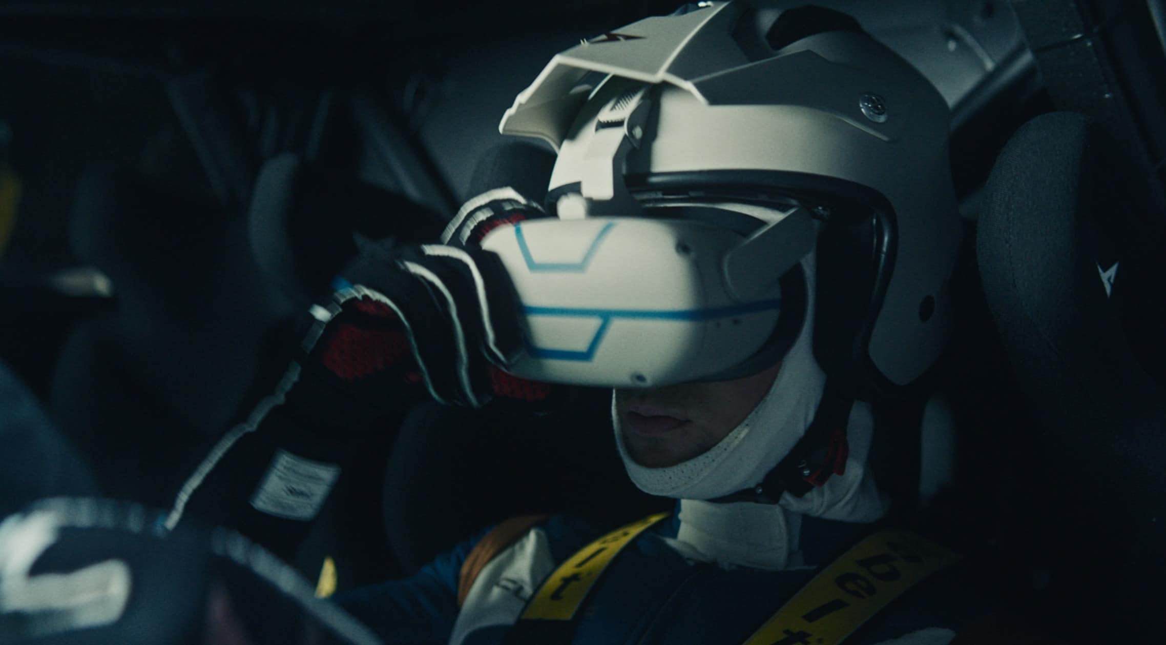 A person wearing a racing helmet and holding a VR device