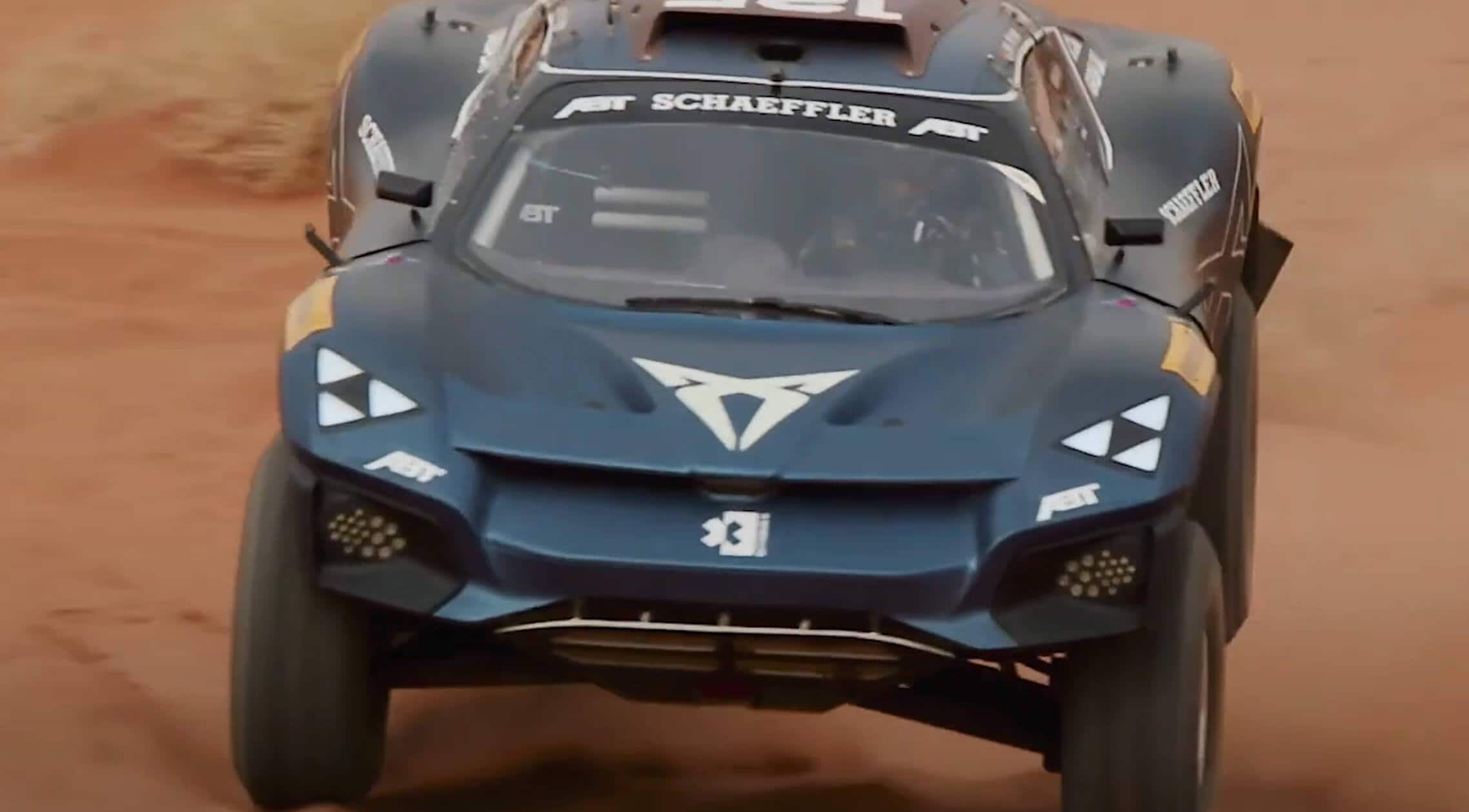 The CUPRA Tavascan XE driving across a sand dune