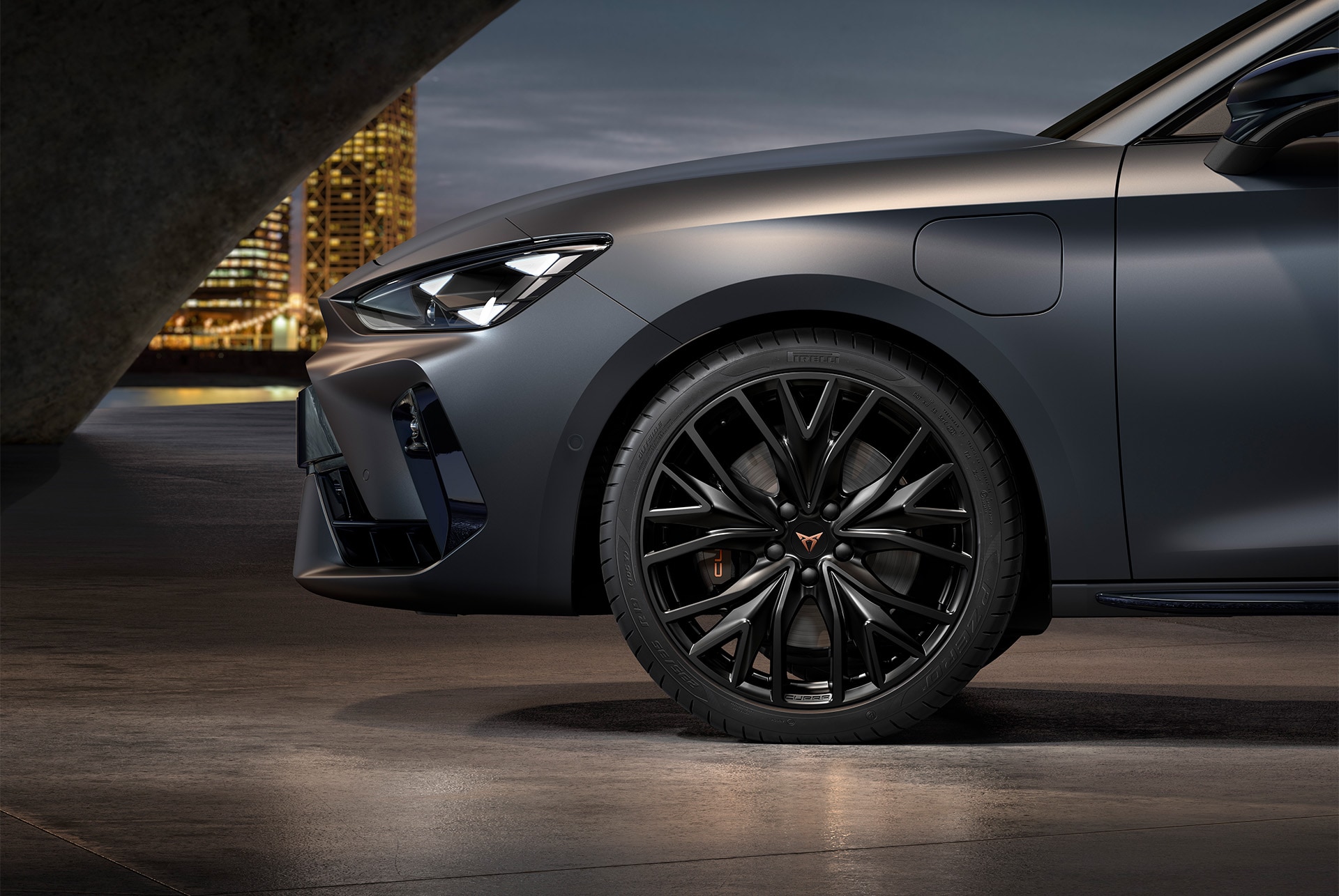 Front side view of left forged alloy wheel in black for the CUPRA Leon, tyres, signature headlights and matt grey body