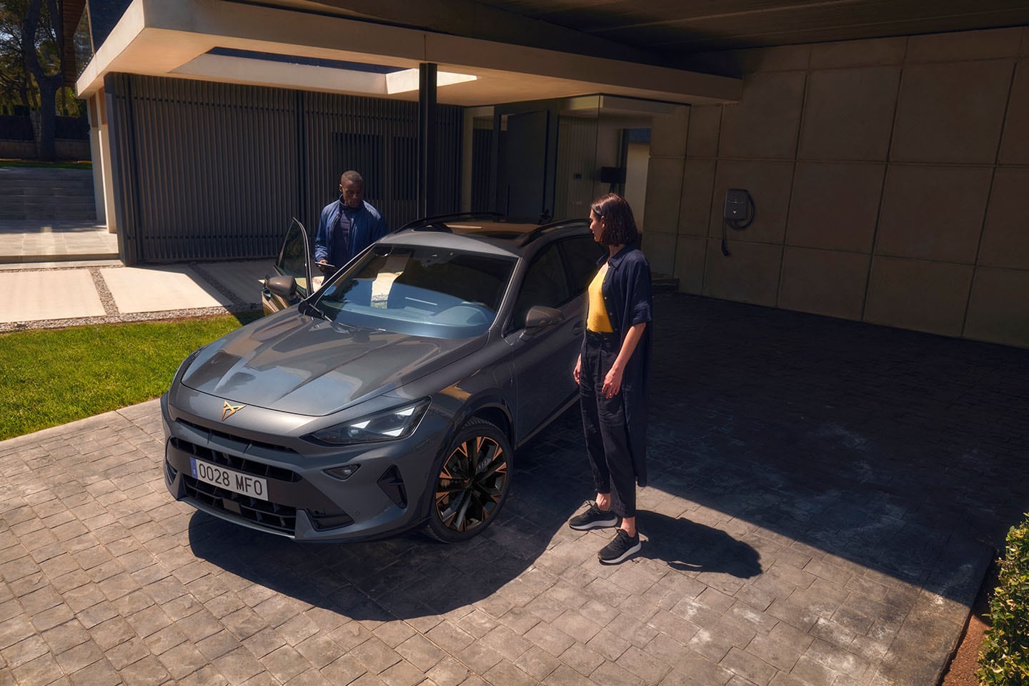 A man exiting a CUPRA vehicle whilst a woman is facing the man on the other side