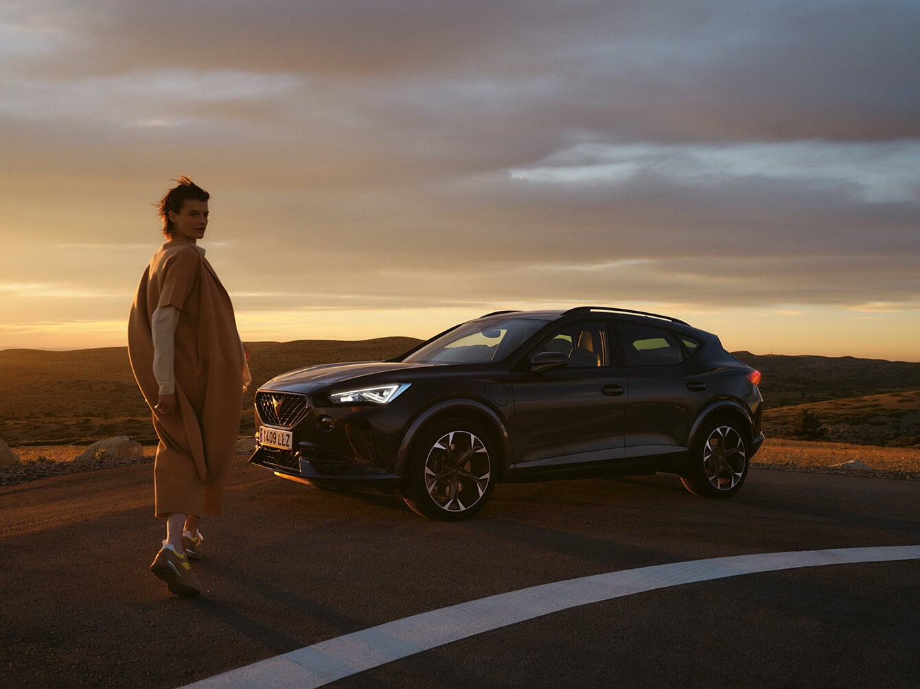 A%20woman%20next%20to%20a%20CUPRA%20Formentor%20on%20the%20road