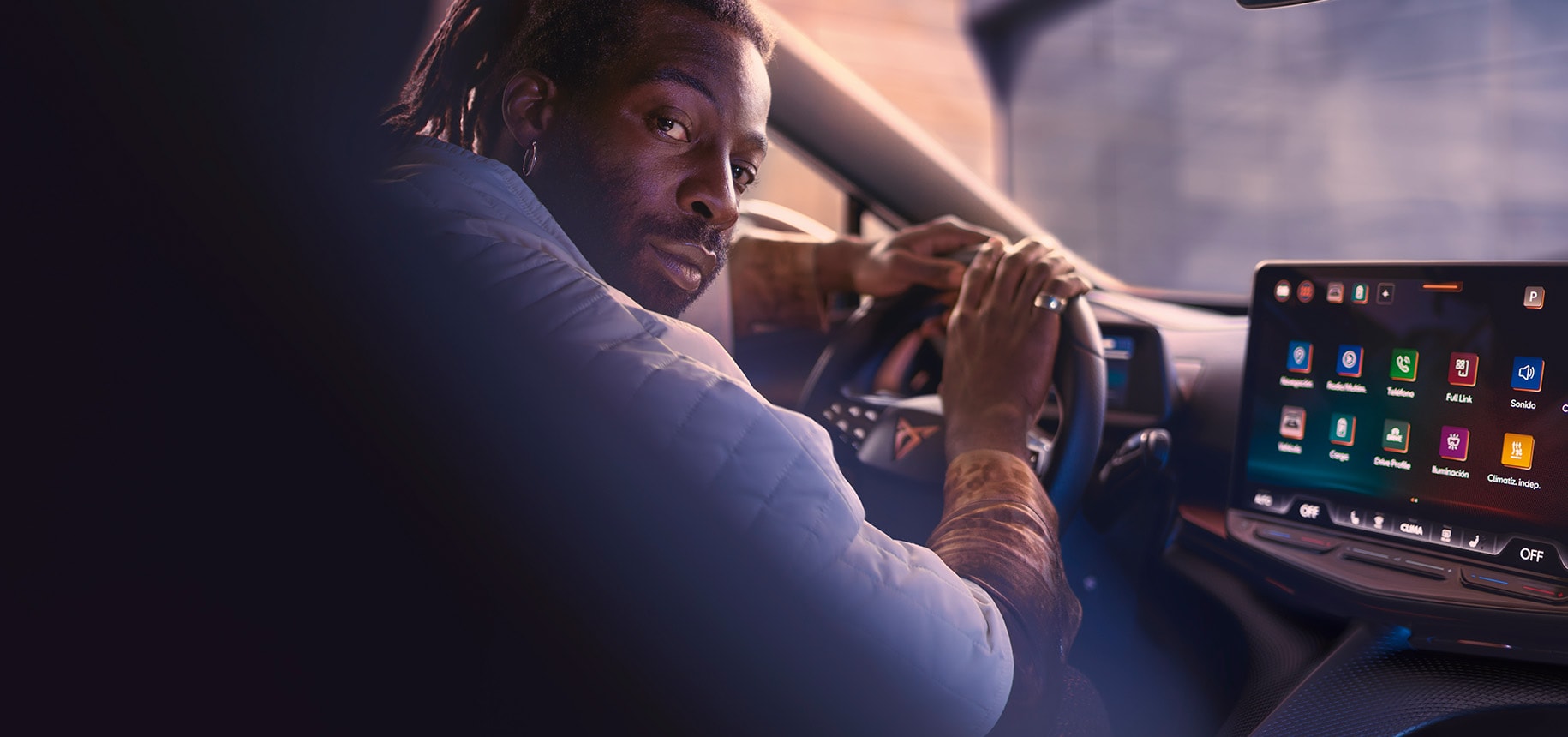 A driver looking over their shoulder inside a cupra car and smiling, illustrating the concept of enjoying subsidies and tax benefits to lower purchase costs and reduce vehicle registration taxes.