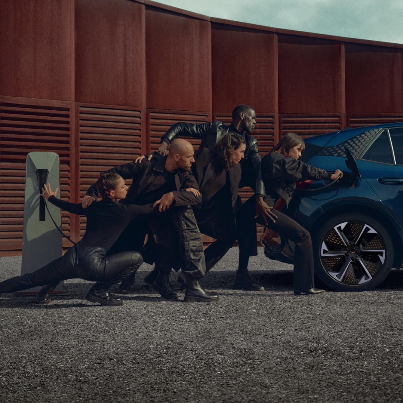 A blue CUPRA Born electric car is being charged at a public charging station.