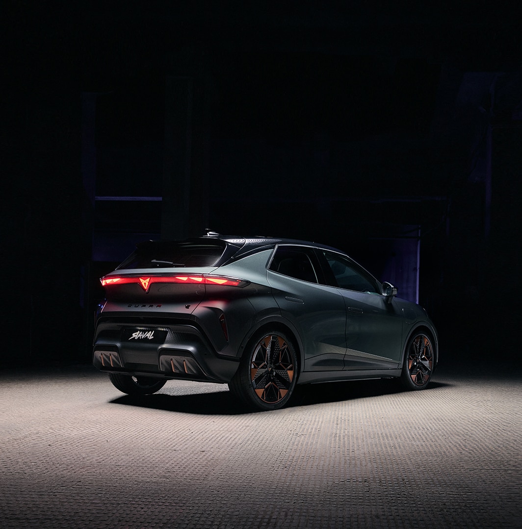 CUPRA Raval Endurance electric car rear view with illuminated taillights in a dark studio setting