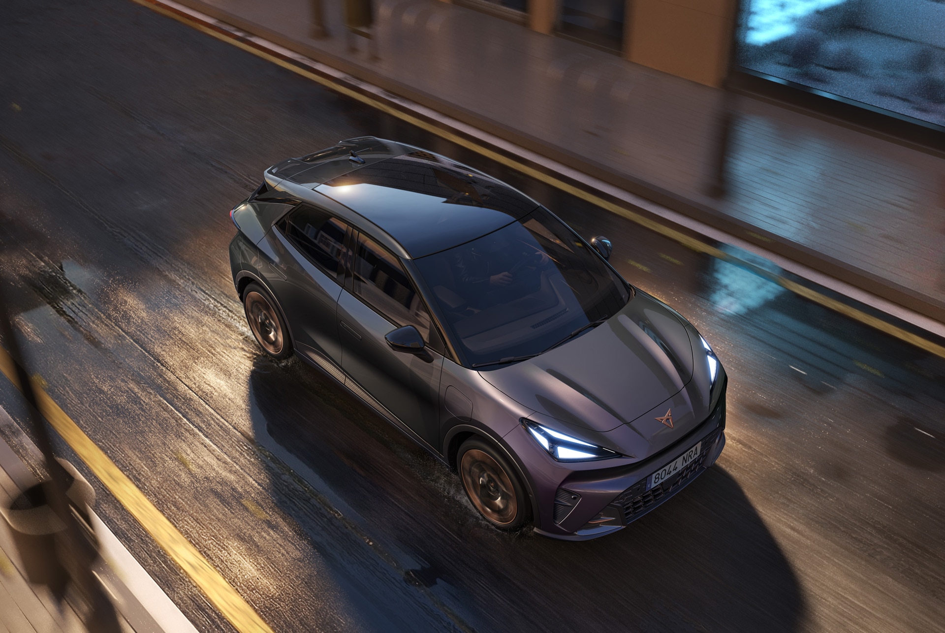 New CUPRA Raval compact electric SUV in motion, aerial front view, night driving.