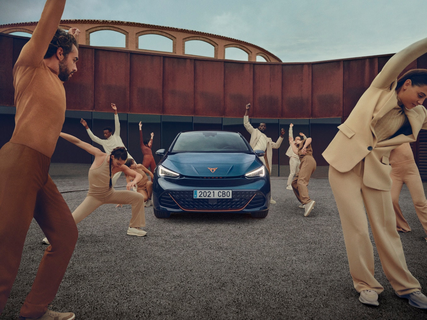 CUPRA Born w kolorze Aurora Blue na tle budynku w mieście