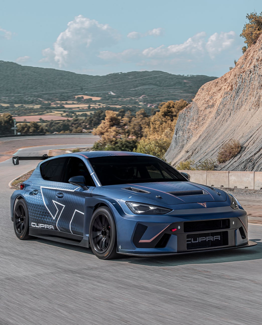 cupra leon vz tcr driving on a mountainous road, highlighting elevated aerodynamics.