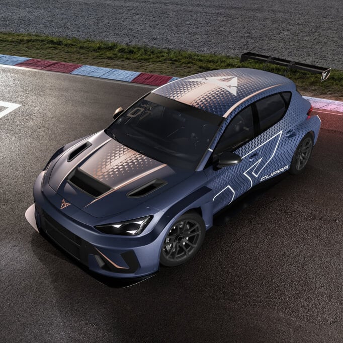 Top down view of the cupra leon vz tcr on the racetrack showcasing its aerodynamic design, vented hood and racing livery under track lighting.
