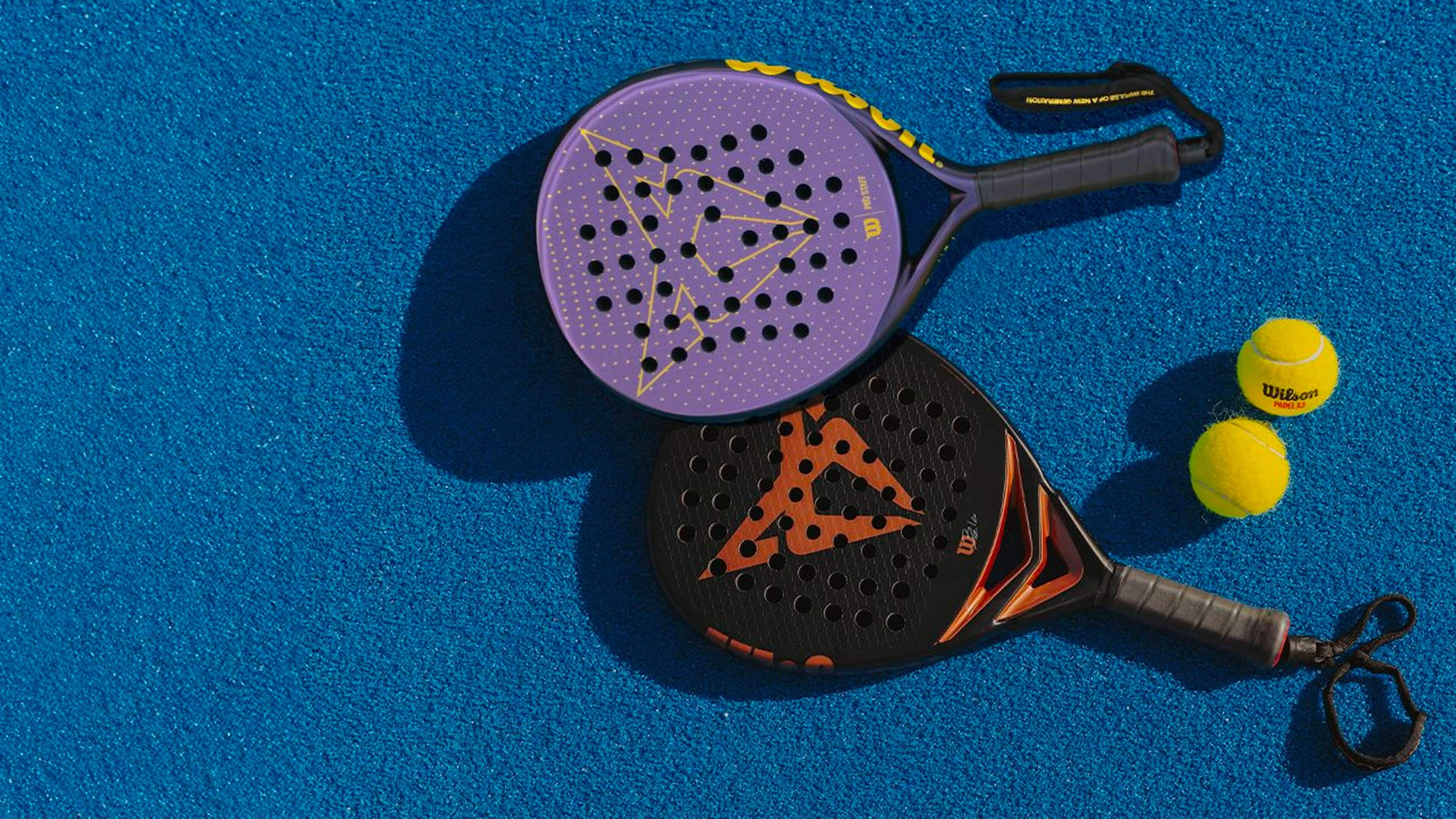 Two padel rackets featuring the CUPRA logo rest on a blue surface alongside Wilson-branded balls.