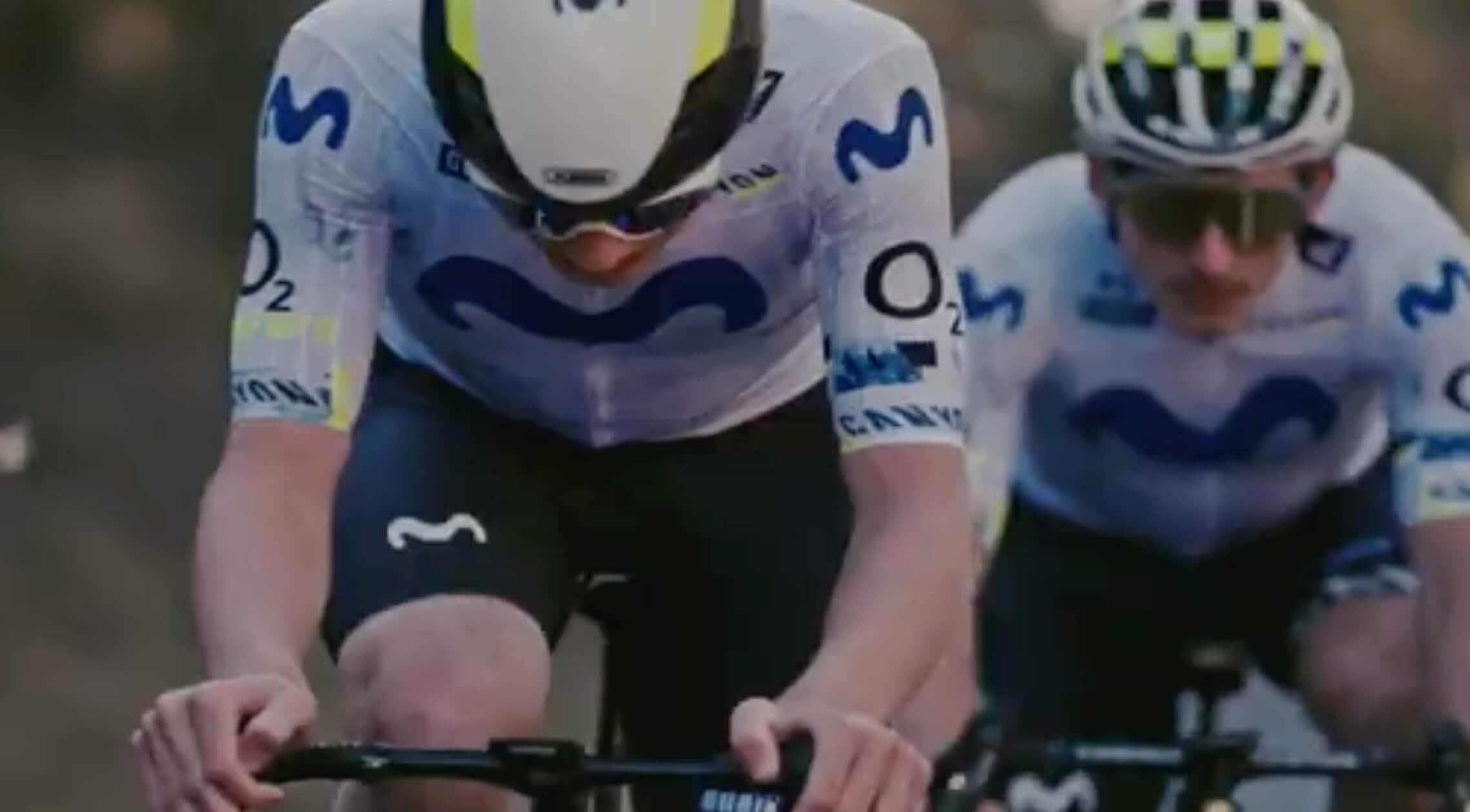 Men riding a bike with helmets and attire with the movistar logo.
