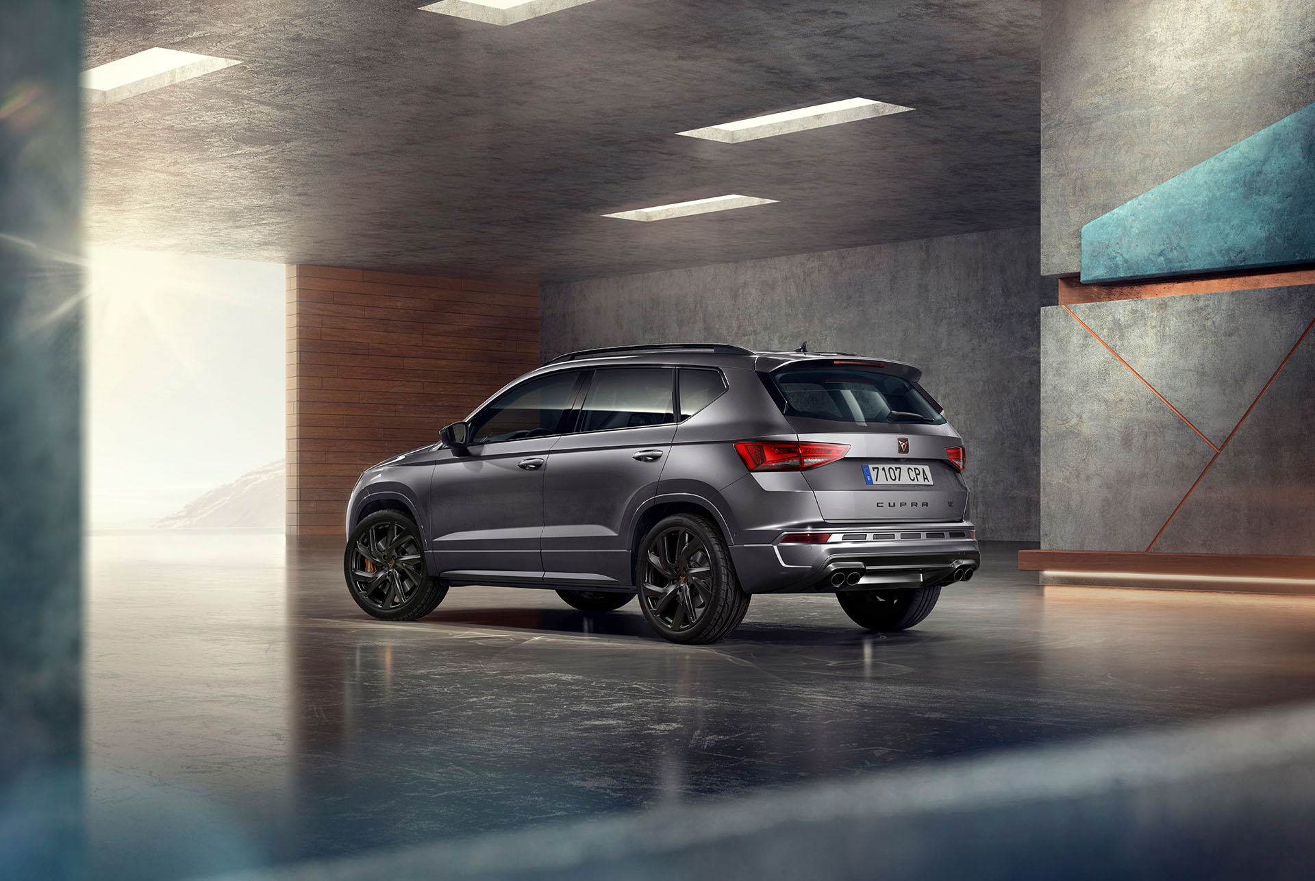 A grey cupra ateca suv displayed against a white background. The car features a bold front grille, led headlights and black matt alloy wheels, highlighting its sporty car design.