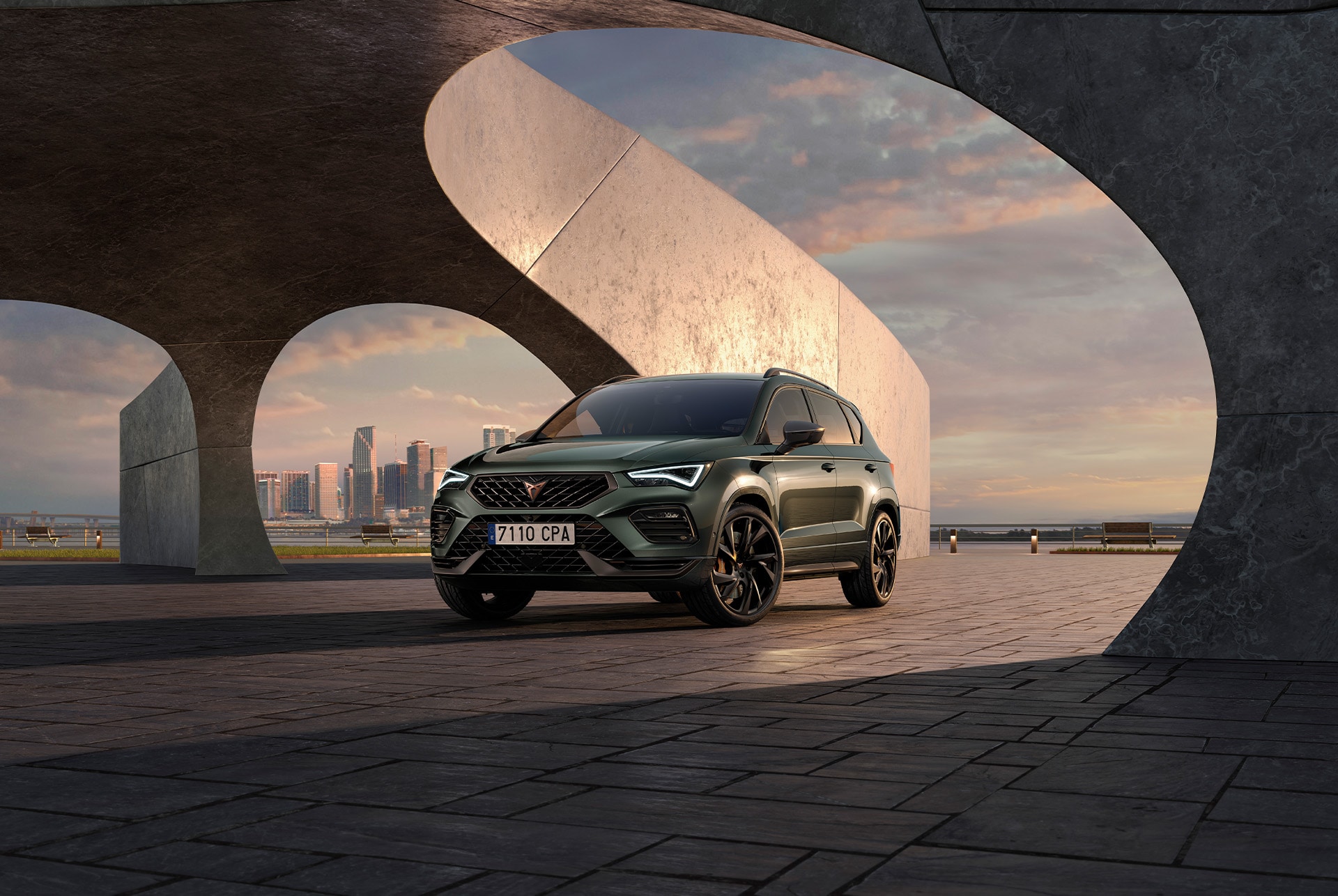 Front view of the CUPRA Ateca Tribe Edition showcasing its striking exterior in Dark Forest and Magic Black, set against an architectural backdrop.