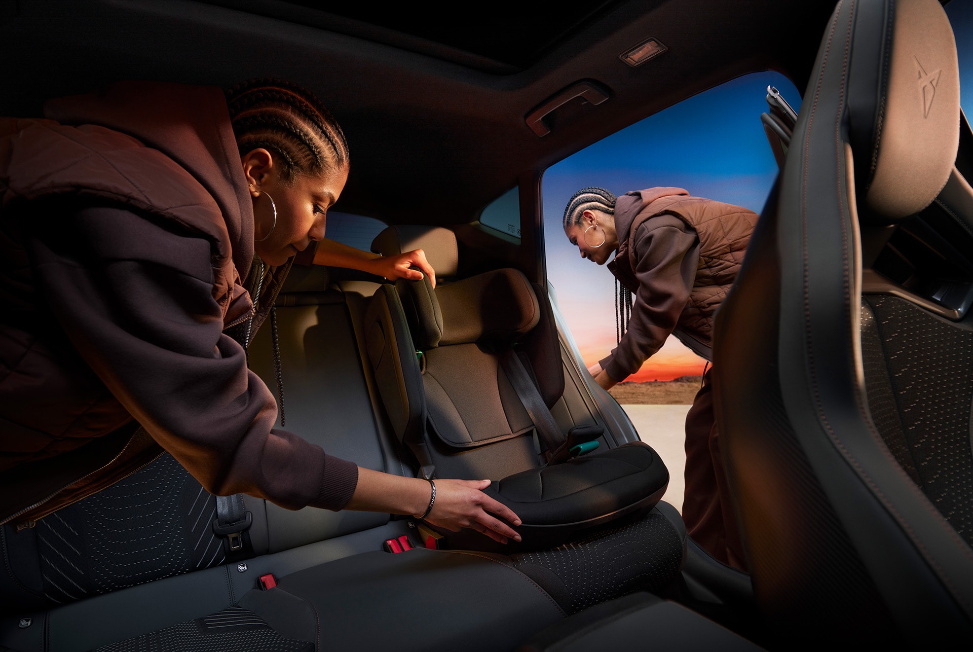 CUPRA Formentor interior showcasing a sleek design, with two individuals setting up the child seat in the back.