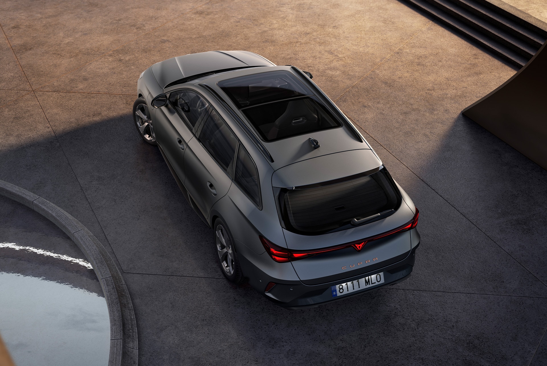 This image features a bird’s-eye rear view of the CUPRA Leon Sportstourer in sleek matte grey. Its sporty and refined design is accentuated by the natural light, showcasing its modern and dynamic styling.