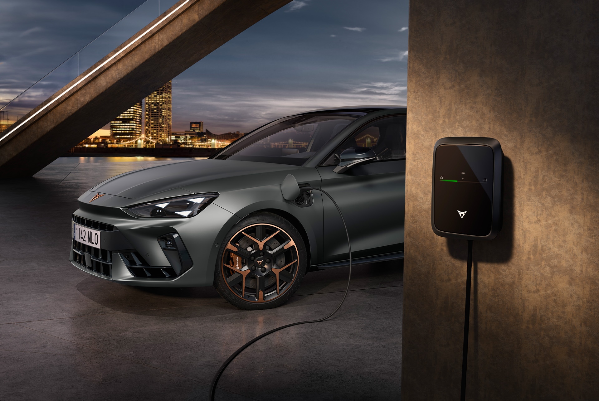 side, half view shot of the cupra leon vz e-hybrid pllugged in a urban setting.