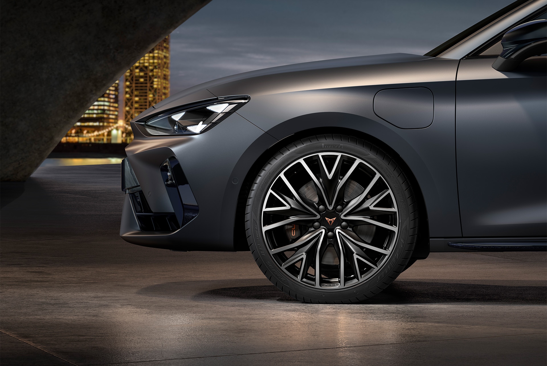 front side view of left mistral machined alloy wheels in silver and black for the Cupra Leon, tyres, signature headlights and grey body.