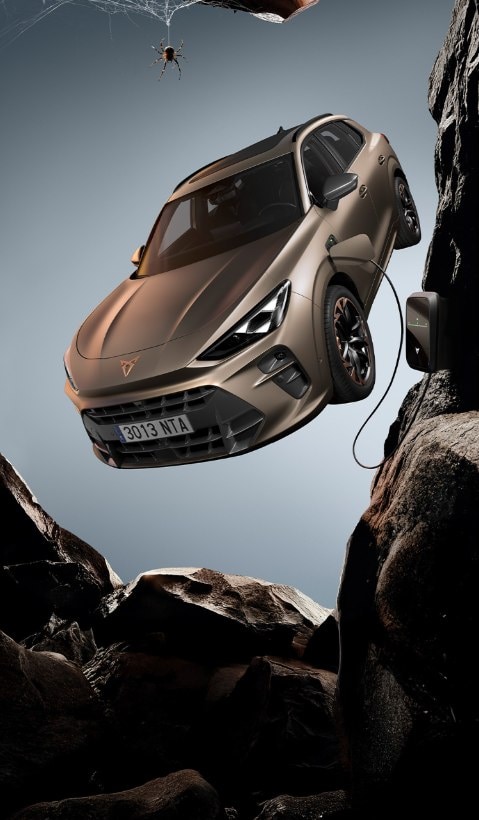 A CUPRA Terramar SUV shown from a high angle, appearing to be in motion with a red light streak extending from its side to a person lying horizontally in the air next to it.