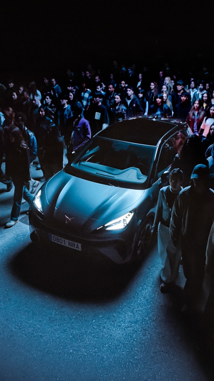Un plano general del CUPRA Raval, un coche eléctrico urbano, rodeado de gente.