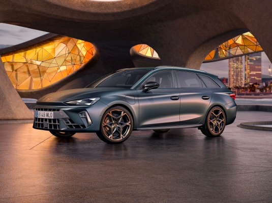 Cupra leon for sale, hatchback in magnetic tech matt grey with 19 inch polar copper wheels and illuminated city background. New car offers available.