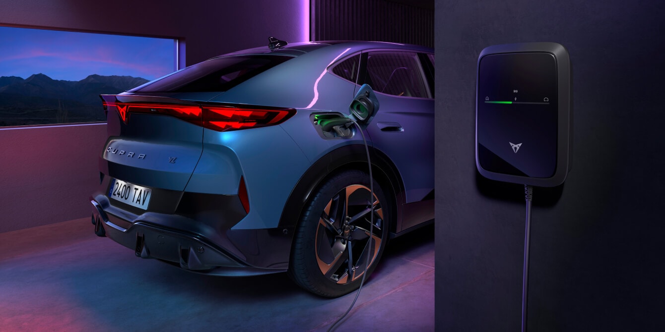 CUPRA Tavascan VZ in blue charging with CUPRA Charger, parked in a modern garage with purple ambient lighting.