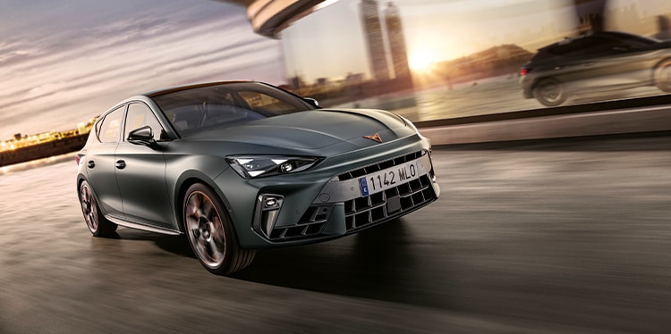 phev cupra leon sportstourer in motion, urban setting at sunset