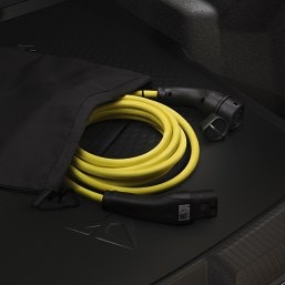 cupra born aurora blue electric vehicle plugged in to domestic plug socket