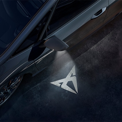 CUPRA brand logo projected on the ground from a car door light.