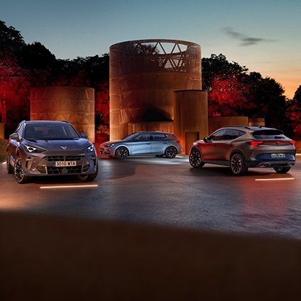 Fleet of CUPRA cars parked in front of a modern corporate building for business solutions.