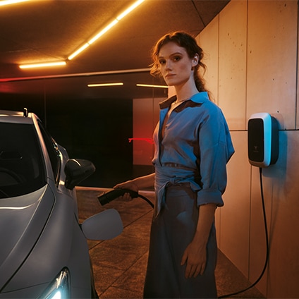 woman charging hybrid cupra formentor with the Volkswagen Group Charging GmbH (Elli) charger for hybrid and electric vehicles