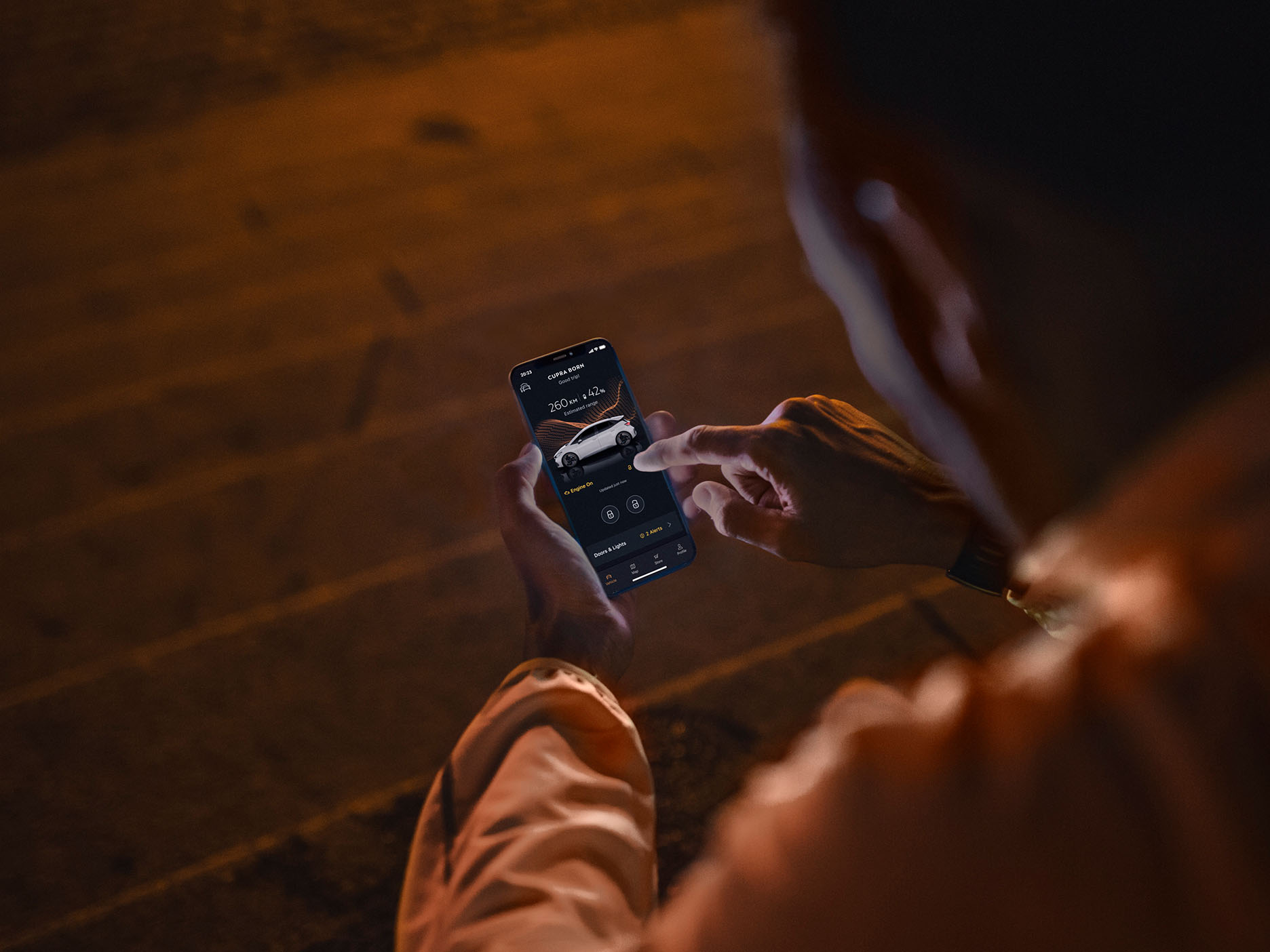 Over-the-shoulder view of a person using the My CUPRA smartphone app to check the status, range, and battery level of a white CUPRA Born electric car.