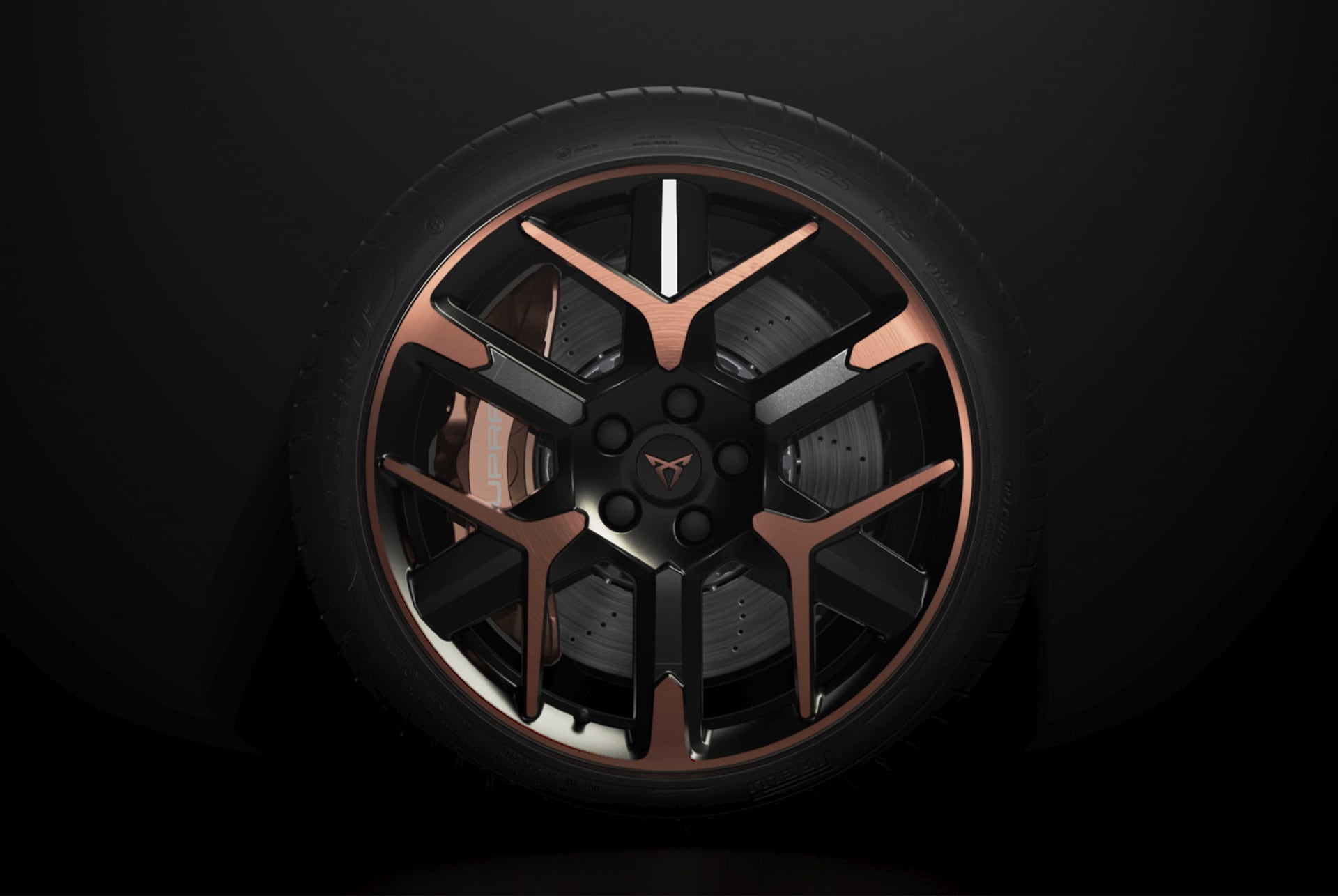 A close-up of a CUPRA car’s wheel with a black and bronze multi-spoke design, against a dark background. 