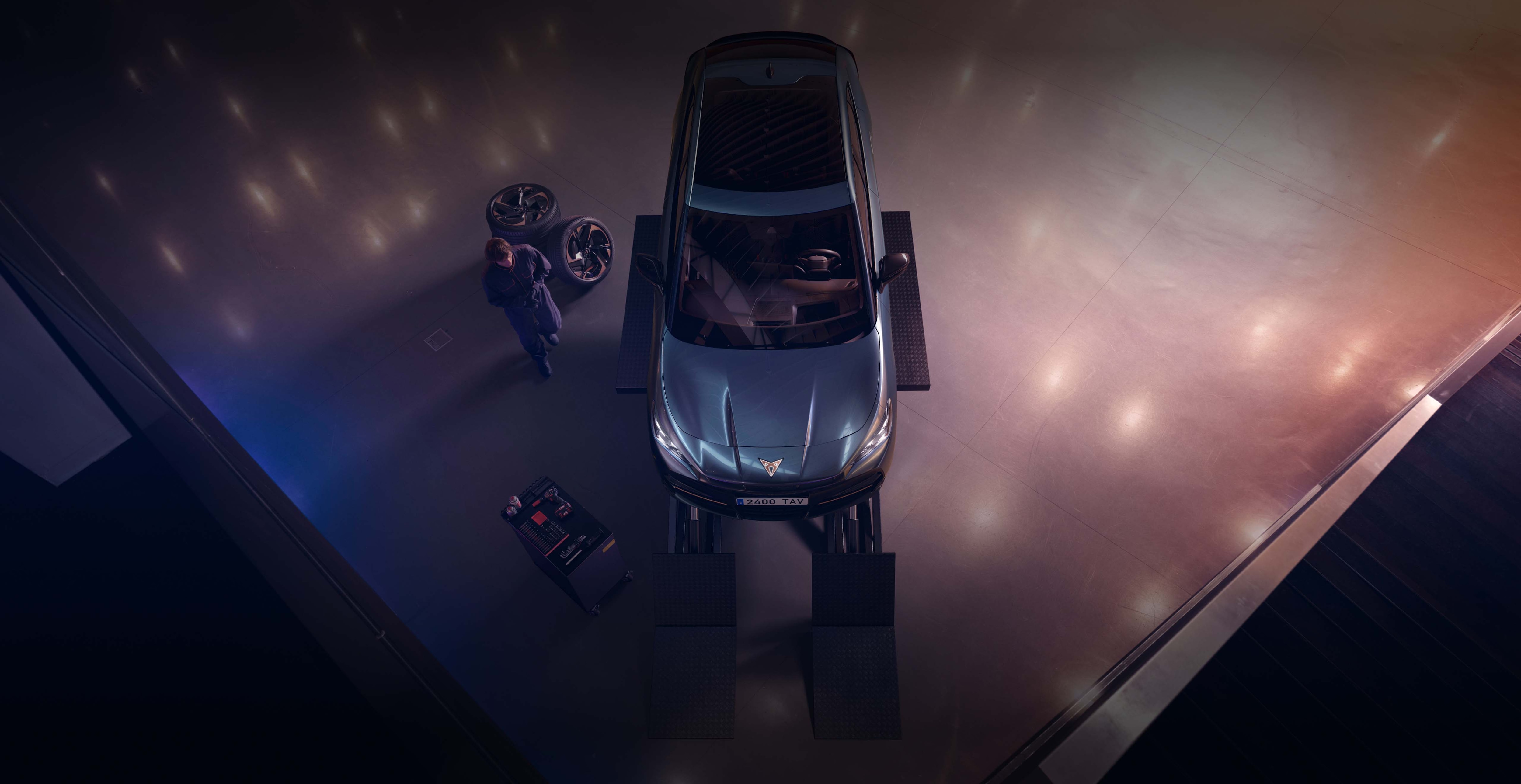 CUPRA Formentor dans un atelier automobile, avec un technicien et des roues à proximité pour une intervention d’entretien
