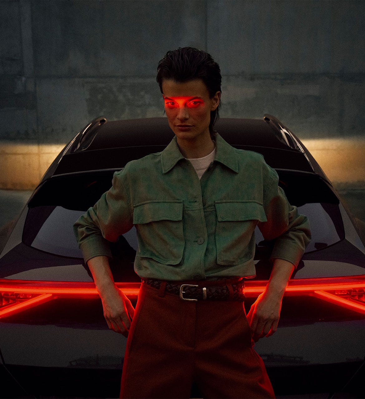 Rear%20view%20of%20a%20Cupra%20Formentor%20parked%20in%20a%20setting%20highlighted%20with%20a%20red%20tone.%20There%20is%20a%20person%20next%20to%20the%20car.