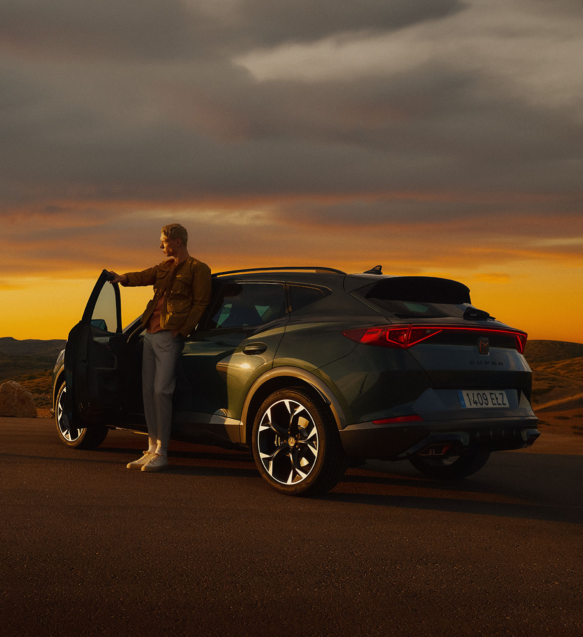 A%20dark%20Cupra%20Formentor%20parked%20on%20the%20side%20of%20the%20road,%20in%20an%20outdoors%20setting.%20There%20is%20one%20individual%20coming%20out%20of%20the%20driver%27s%20side,%20and%20another%20outside,%20facing%20the%20car.